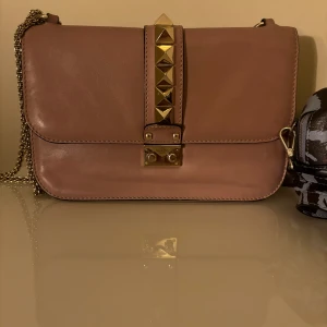 Valentino glam lock - Rosa valentino väska i modellen glamlock, har fått en liten defekt längst ner men  går lätt att fixa vid inlämning