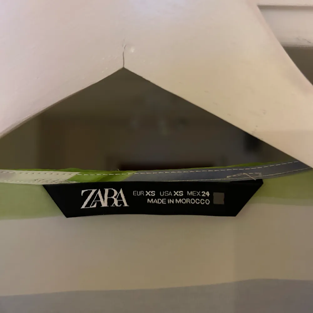 Storlek: XS En skjorta från Zara med detaljer som knappar längst ner vid ärmarna samt ett snöre som man knyter ihop skjortan med. Den är i ett fint skick då den är använd ett fåtal gånger.  Köparen står för frakten . Blusar.