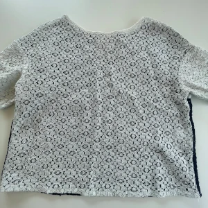 Prerdarten t-shirt  - mönstrad t-skirt med vita ärmar, framsida och mörkblå baksida. Det står tyvärr inte vilken storlek tröjan är i men skulle nog tro i S/M. 