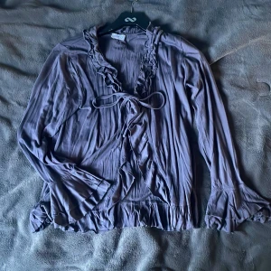 Volang kofta - Grå lila gullig volang kofta i ett jätte skönt material. Snören fram där man kan knyta. Står ingen storlek men jag skulle gissa på s-m.