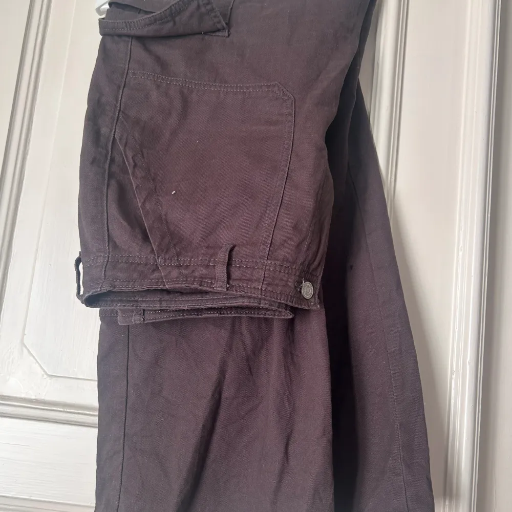 Bruna cargobyxor med fickor och knapp framtill. . Jeans & Byxor.