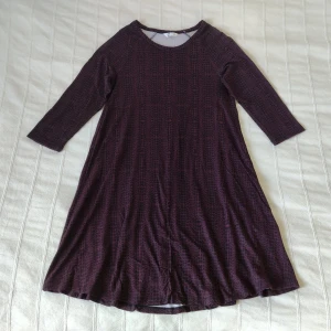 Mönstrad lila/svart klänning, storlek XS - Mönstrad klänning från Cubus. Väldigt mjuk och elastisk. 92% viskos och 8% elastan. Bara använd en gång och är så gott som i nyskick. Storlek XS, men tror att den kan passa större storlekar också.