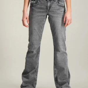 Grå jeansbyxor - Ett par grå jeansbyxor med en rak passform. Byxorna har en klassisk femficksdesign och är tillverkade i ett slitstarkt material.