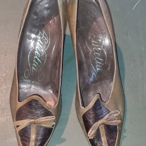 Bruna pumps med rosett - Ett par eleganta vintage bruna pumps med spetsig tå och en dekorativ rosett framtill. Skorna har en liten klack och är tillverkade i skinn.