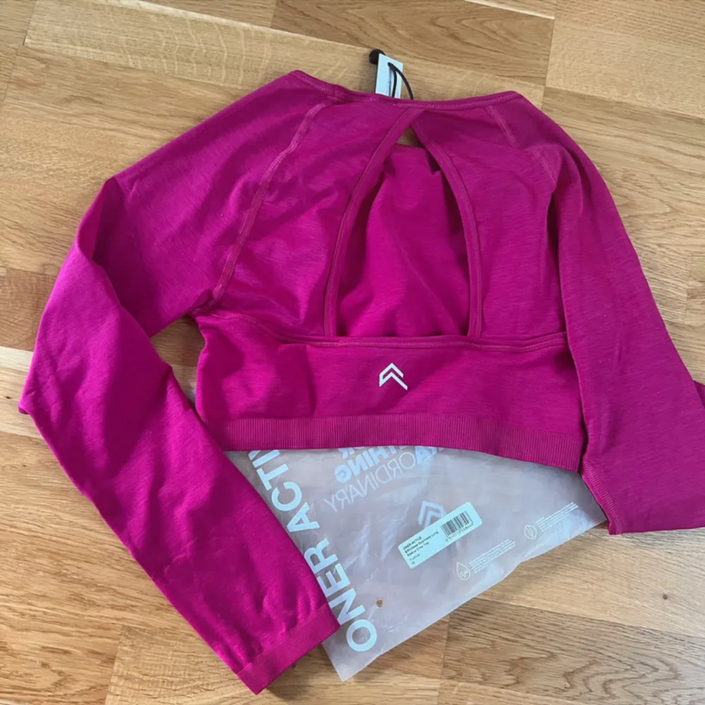 Long sleeve crop top från Oner Active i storlek M. I färgen fuchsia. Helt ny/oanvänd och inget att anmärka på. 54% polyamid, 40% polyester, 6% elastan.. Sportswear.