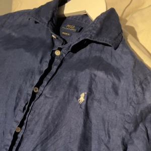 Ralph Lauren Skjorta 8 / S - Tja! Säljer denna feta Ralph Lauren linneskjorta för endast 299kr! Den är väldigt fräsch och har inga större defekter. Den är i storlek 8 vilket motsvarar storlek: S.  Glöm ej att checka min andra raffe skjorta i min profil, Ställ frågor om ni har! 🐺