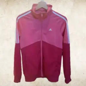 Rosa adidas track top, sitter tajt trots att lappen säger XL. Använd ca 2 gånger, bra skick. Orginalpris 250 kr.