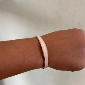 Ljusrosa justerbart armband - Rosa armband med guldfärgat på kanten. Går att justera storleken. Ej riktigt guld, rostar inte! Skriv för fler frågor eller bilder.