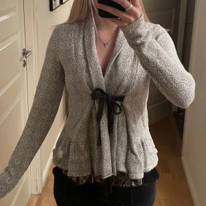 Grå vit odd molly kofta med knytning rosett - Superfin gråvit kofta med rosettknytning som går lite omlott. Märket är odd molly och storleken är 1 vilket motsvarar en S. Den är i så bra kvalitet och den är verkligen jätteskön. Nypris: 1700kr