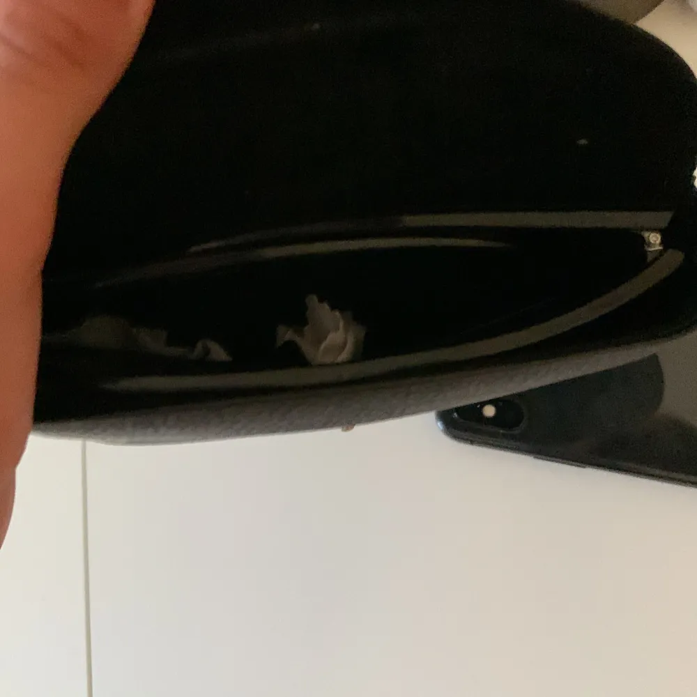 Säljer ett svart fodral för Ray-Ban glasögon. Fodralet är gjort av ett slitstarkt material och har en knappstängning. Perfekt för att skydda dina glasögon när du inte använder dem. Fodralet har en guldig logotyp på framsidan.. Accessoarer.