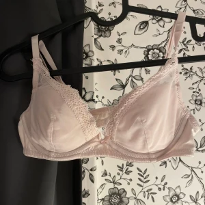 Ljusrosa spetsbehå - Säljer en söt ljusrosa behå med spetsdetaljer. Behån har justerbara axelband och en liten rosett framtill. Perfekt för en romantisk look eller bara för att känna sig extra fin. 💕