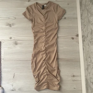 Klänning - En fin beige klänning med skrunch fram och bak💕🤩Köpte den från H&M:) Fint skick och använd få gånger💕🫶Säljer för 49kr💖🤗Storlek XSS💕
