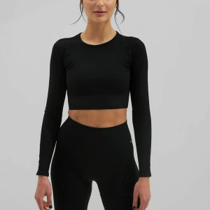 Svart ribbad croppad topp - Säljer en snygg svart ribbad croppad topp med långa ärmar från Aimn. Perfekt för både träning och vardagsbruk. Den är använd några gånger men fortfarande i väldigt bra skick! Säljs för 150kr💗