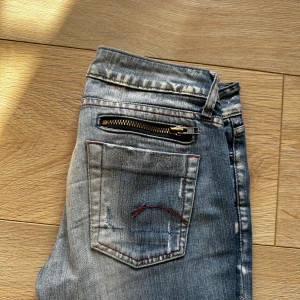 G-Star Lågmidjade jeans  - Säljer dessa super snygga jeansen från G-Star som är Lågmidjade och raka i modellen! De slitningar är modellen och inget som uppkommit under tiden jag haft dom, de är i storlek 26/32 💖