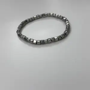 Jättefint silvrigt armband med fyrkantiga pärlor som är dessutom elastiskt! Aldrig använt!! 