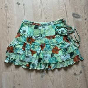 Grön blommig kjol från Wezc med volanger i storlek S. Fint skick. Använd gärna köp nu! 