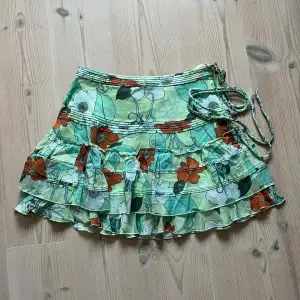Grön blommig kjol från Wezc med volanger i storlek S. Fint skick. Använd gärna köp nu! 