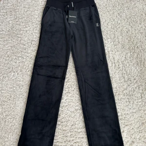Svarta nya Juicy Couture - Nya Juicy Couture byxor i svart med diamantdetaljer där bak. Storlek S men passar även M!