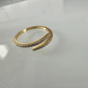 Justerbar 💍  - Svep in dig i glittrande stil med skimrande bandring i sterlingguld. Elegant, stilren och slående – den här asymmetriska ringen är en fräsch twist på en klassisk design och utgör ett fantastiskt tillskott till din look.