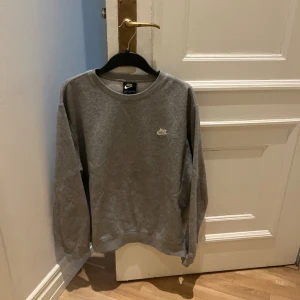 NIKE collegetröja sweater  - Ljusgrå NIKE collegetröja sweatshirt med NIKE text och logga i vitt på vänstra bröstet