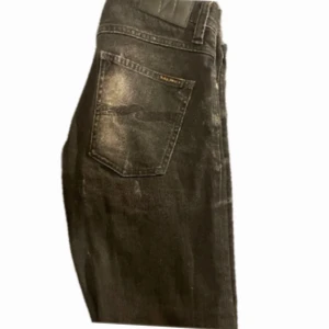 Nudie jeans - Nudie jeans fint skick Storlek w29 L32 Sitter tajt  Dom är mörk grå/svart färgen är utvättad men det är så det ska vara dom är Ripped. skriv vid frågor samt intresse.