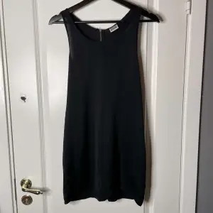 Kort svart klänning med dragkedja baktill i storlek S.