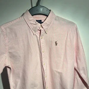 Ralph lauren skjorta - Säljer nu denna vit/rosa ralph lauren skjortan. Den är i Rls storlek 8 vilket blir som 36 eller ja storlek S då kanske något mindre. Skjortan är i 9/10 skick och har 0 flaws eller missfärgningar. Tar emot byten och skriv om du har någon fråga!!