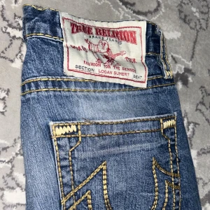 True Religon Jeans - Säljer mina gamla true religon byxor eftersom dem är lite för stora på mig<3 väl omhändertagen och inga hål förutom lite sliten längst ner vid benen. Kontakta för fler bilder. Är öppen för byten (miss me, rock revival elr trueys)