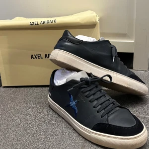 Axel Arigato Skor - Säljer nu min Arigatoskor för att de har blivit för små, allt original följer med dvs box, dustbag mm. Finns en liten defekt på vänster sko som man absolut inte tänker på eller som man knapp ser. Hör av er vid frågor och funderingar! Kvitto finns!😃😀