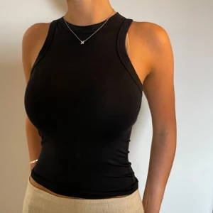 Svart halterneck topp - Svart Halterneck topp från Zara i stretchigt ”träningskläder” material, lite shimmrigt o mjukt lixom haha:) använd ca 1 gång💓