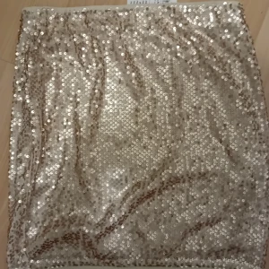 Paljettkjol - Guldig kort paljettkjol från Lindex strl M