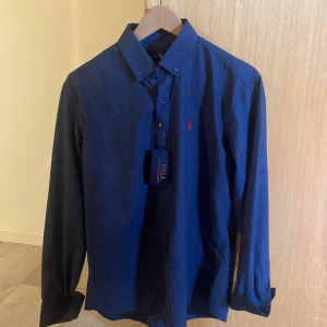 Ralph Lauren Skjorta - Mörkblå ralph lauren skjorta perfekt till sommaren, aldrig använd pga att den är för stor och säljer därför, storlek L men passar Medium oxå