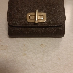 Michel kors plånbok  -  Säljer min Michel kors plånbok brun monogram  sparsamt använd inköpt på zalando, mått 11 cm lång och 9 cm hög vidd 3 cm. 