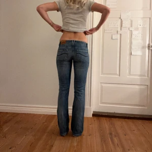 Lågmidjade jeans  - Lågmidjade vintage jeans.  Jag på bilden är 170cm.  Midjemåttet: 37cm (rätt över )  Lårmått: 23 Inerbenslängd: 77cm Inga defekter 💕 använd dig utav köp nu🫶 
