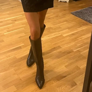 Stövlar cowboy - ”Cowboy” stövlar med en liten klack som går upp till knäna på mig som är 1,68cm lång! Köpa i december och använda 3 gånger.  Inga defekter alls! 