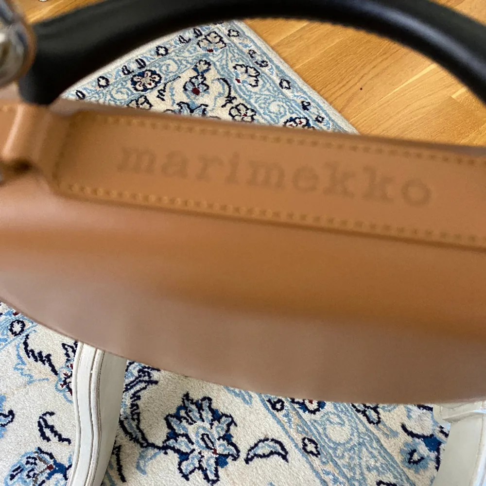 Marimekko crossbody väska i äkta läder. Aldrig använt och köpt för cirka 2800 kr. Går att hämta i Majorna, centrum eller fraktas mot avgift. Inga fläckar eller defekter. Metalldetaljer i silver.  Höjd 20 cm. Bredd 17 cm, djup 7,5 cm.. Väskor.