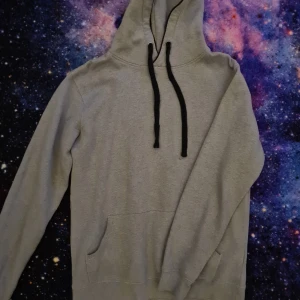 Grå hoodie - Vanlig grå hoodie med svarta detaljer.