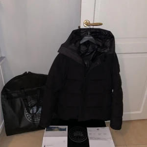 Canada Goose MacMillan Parka Black Label - Beställdes vintersäsongen 2022/2023. Storlek L.  Den är väl omhändertagen. Väldigt fräsch. Väldigt varm & bekväm  Två ytterfickor samt en innerficka vid bröstet (alla med dragkedja)  Nypris idag: ca 14 000 