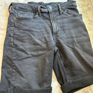 Svarta jeansbyxor  - Svarta jeansshorts från HM i storlek 30. Har ett extremt mjukt material och blir därför lätt att röra sig i. Jeansen är vikta längst ner vid låren och fickorna är stora nog. En perfekt byxa för sommaren! 