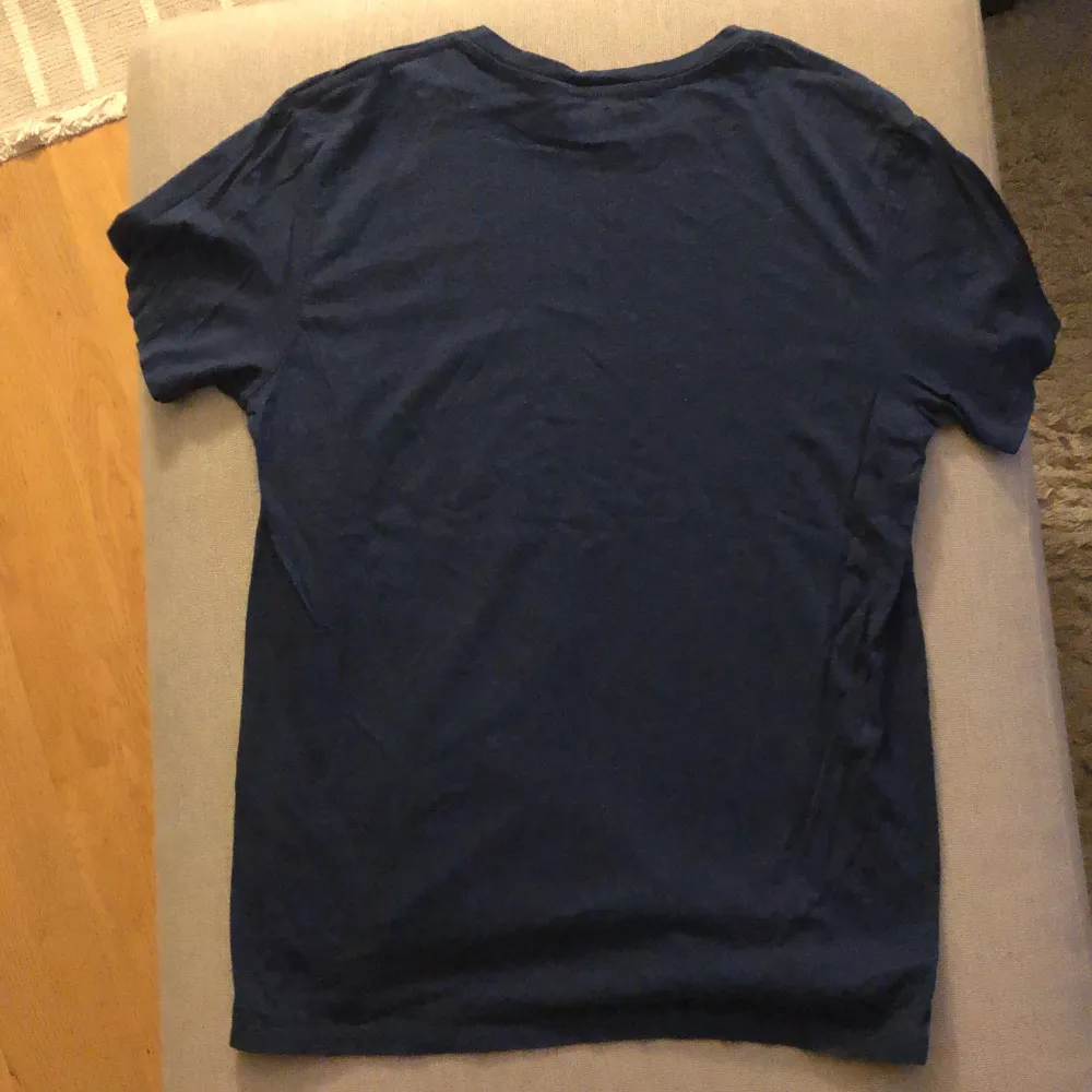 En mörkblå t-shirt från Levi's med korta ärmar och en tryckt logotyp i vitt, rött och blått på framsidan. T-shirten är tillverkad i Turkiet.. T-shirts.