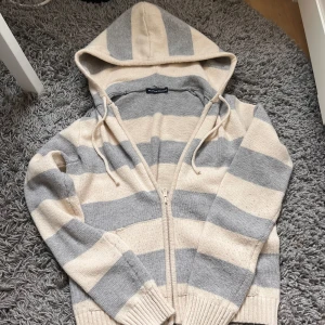 Kofta - Värdens gosigaste kofta från Brandy Melville kofta! Beige blå ränder och luva. verkligen så populär!! Lite nopprig men inget man tänker på❤️