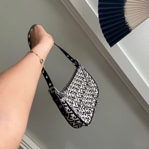 Monogram väska - Axelväska med bokstavsmönster och dekorativ silverfärgad kedja, som ny! Använd EN gång. Remmen är justerbar. 💘