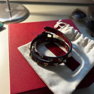 Valentino armband - Säljer mitt otroligt fina valentino rockstud armband i den röda färgen, det är väl använt men har inga defekter och är väl omhändertaget. Säljer då det inte kommer till användning längre. Köpte det på vestaire och har äktenhetsbevis därifrån🥰🌟