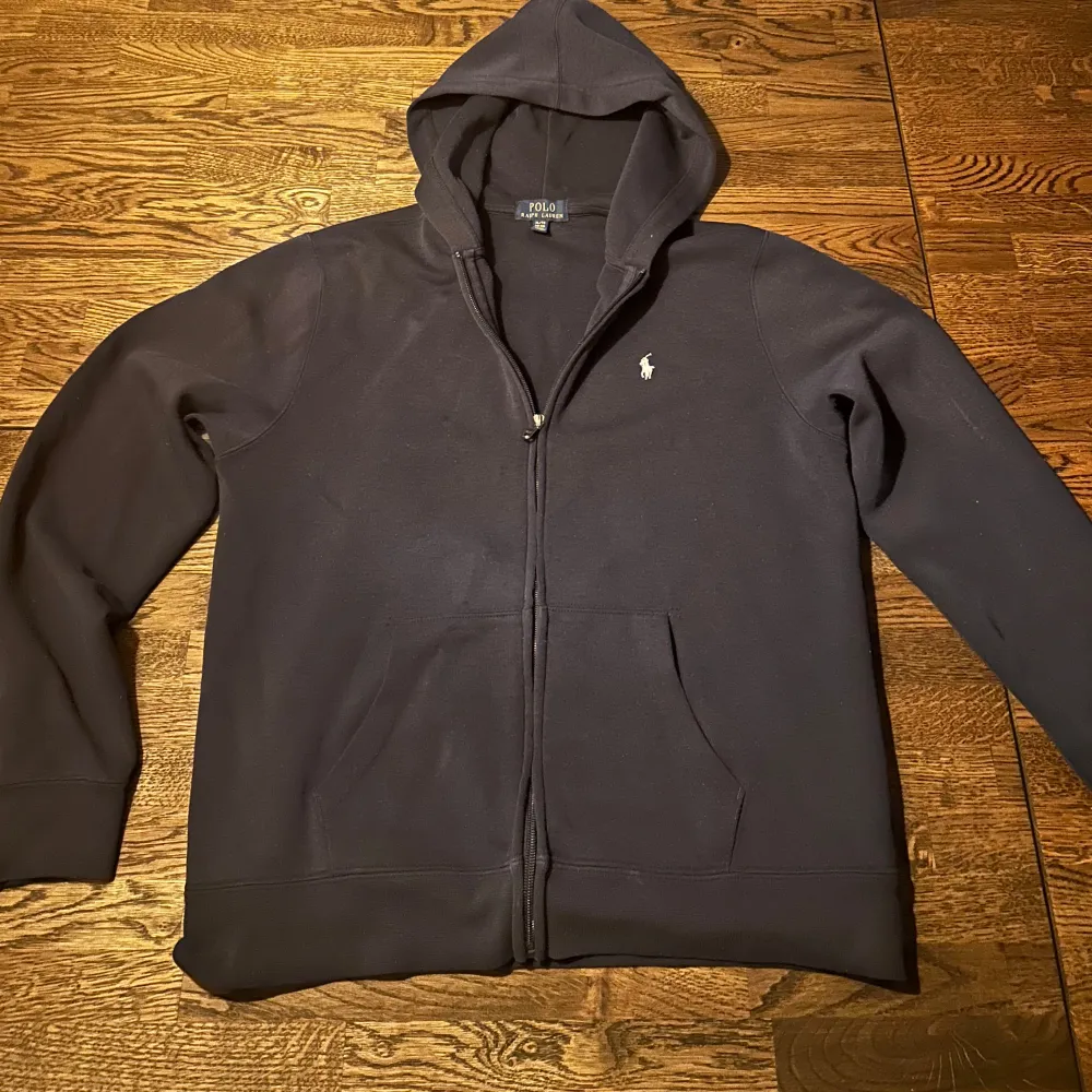 Säljer en Ralph Lauren zip hoodie som är i färgen mörk blå. Det är en lite äldre modell på tröjan men ändå i bra skick. Den passar folk som har storlek S. Tveka inte att höra av er ifall ni har frågor!. Hoodies.