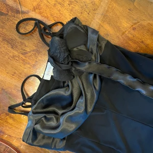 Svart klänning  - Svart klänning, satin blomma