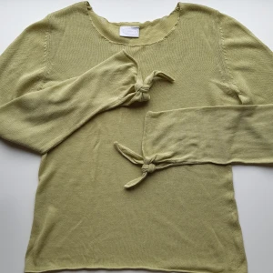 Tunnt stickad tröja - Ljusgrön/nästan åt neongrön, tunnt stickad tröja med fina knytdetaljer på ärmarna. Tröjan är något genomskinlig. Skriv vid frågor! 💕☀️