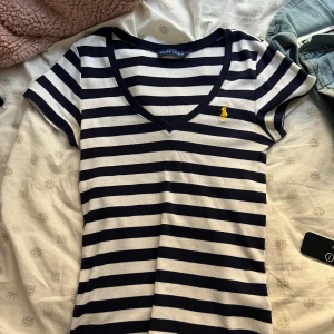 Ralph lauren tshirt - Aldrig använd ! Sjukt skön och snygg lite mer ribbstickad tshirt i mörkblå, vit och gul logga 