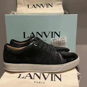 Lanvin sneakers - Lanvin sneakers med glans i ett toppen skick. Allt OG finns ( 2 dustbags, kvitto och extra skosnören). Köpta för 4299kr på NK och säljs för endast 3099kr. Perfekta för alla som vill ha grisch stilen!!!