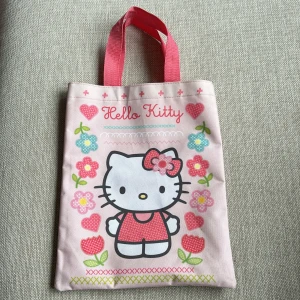 Väska Hello Kitty - Söt shoppingväska i form av en påse med Hello Kitty. Två handtag i rosa.  Storlek ca 31x25 cm