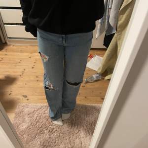 Högmidjade jeans med hål. Välanvända och lite slitna längst ner. 